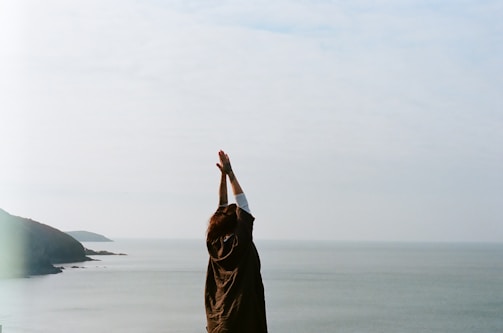 woman in brown hijab covering her face with her hand