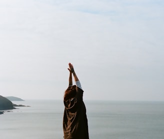 woman in brown hijab covering her face with her hand