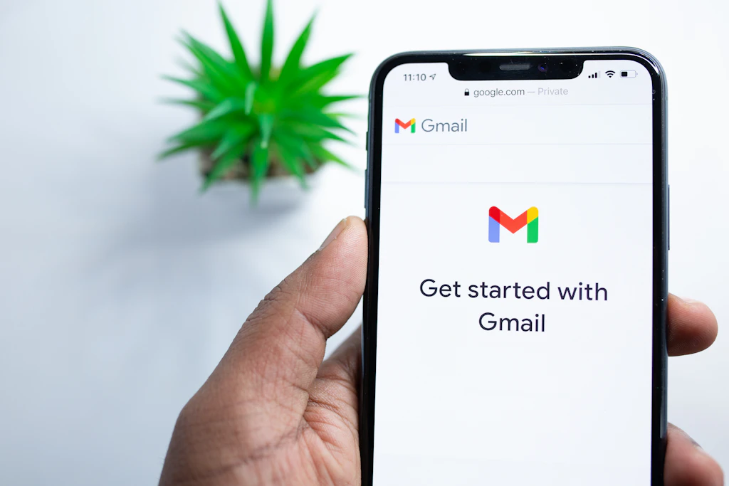 Person holding phone showing Gmail inbox
