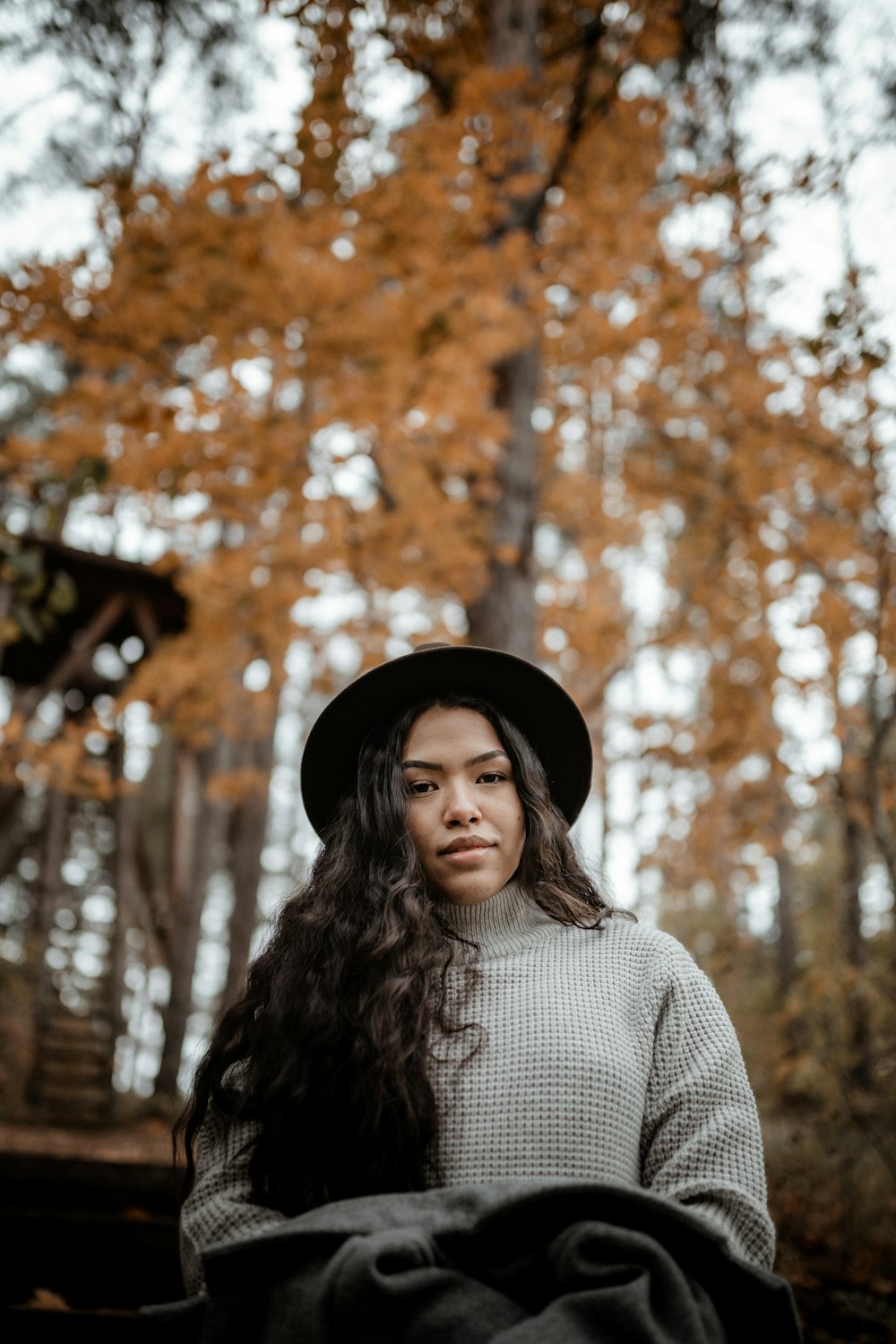 Mujer con sombrero negro y camisa a rayas blancas y negras