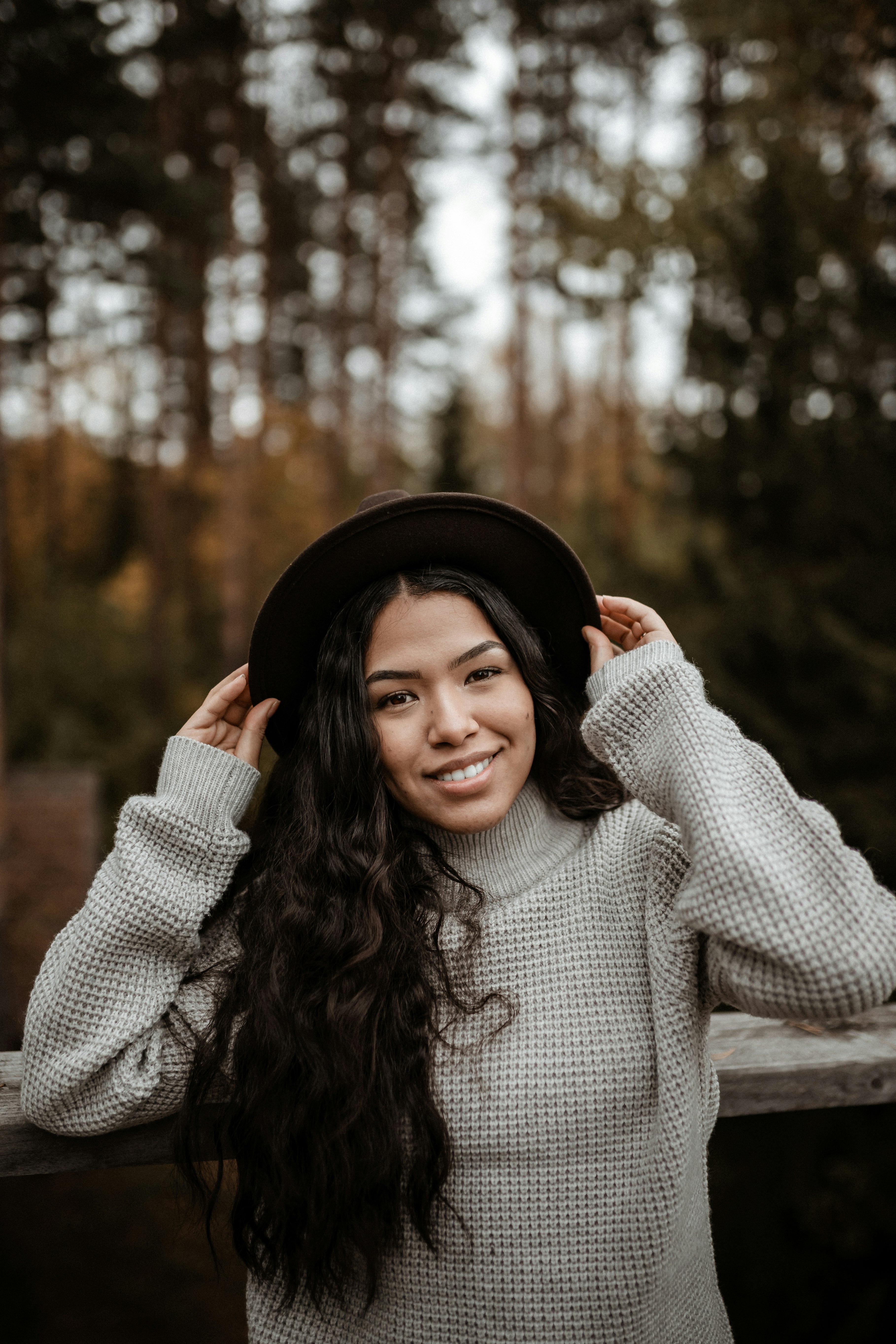 woman in black hat and gray sweater smiling
