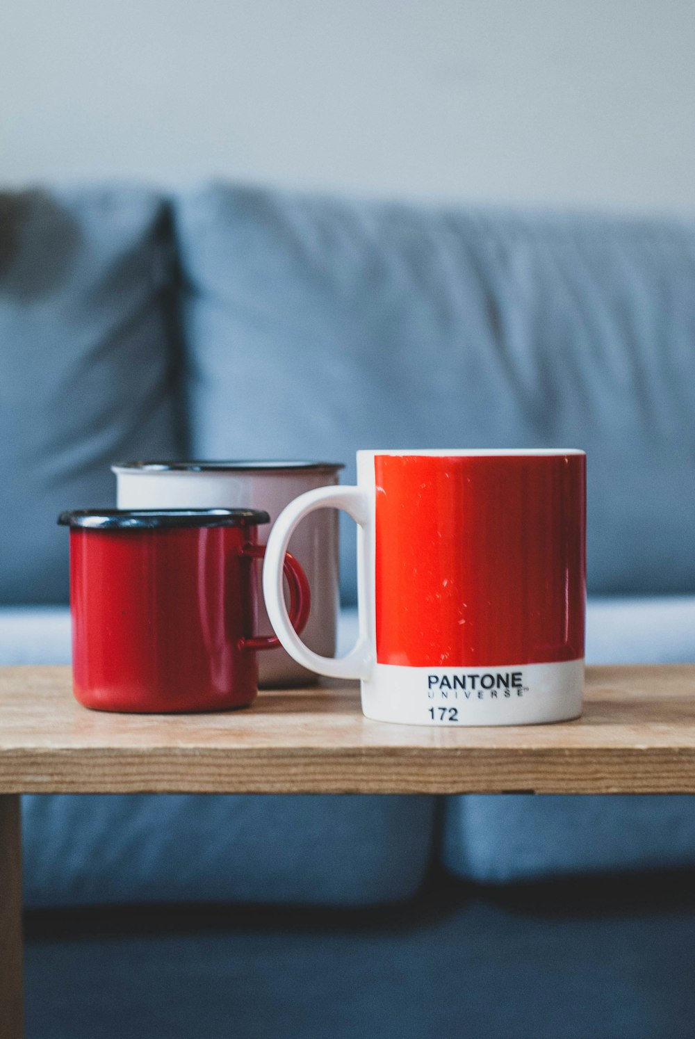 Taza de cerámica blanca y roja sobre mesa de madera marrón