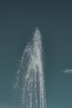 Close-up of a water monitor spraying a strong, steady jet of water against a clear sky.