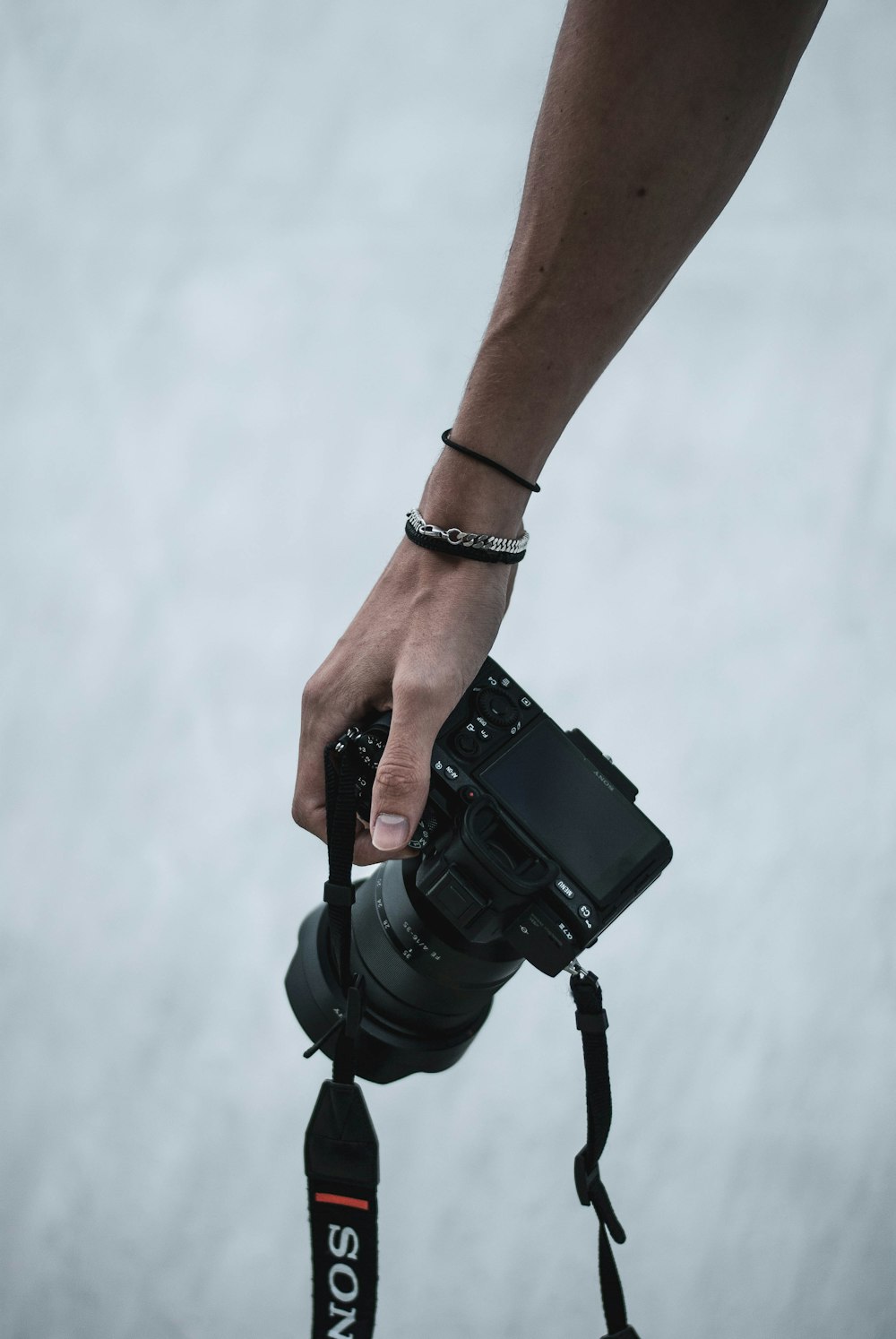 Persona sosteniendo una cámara réflex digital negra
