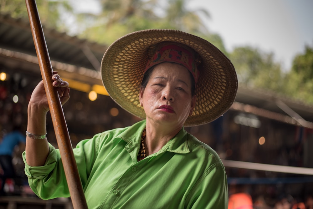 man in green polo shirt wearing brown straw hat