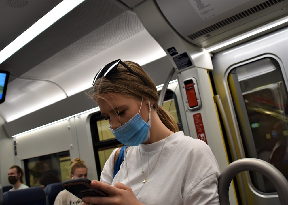 woman in white hoodie wearing blue headphones