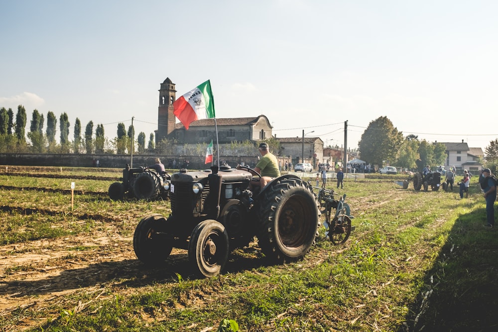 tractor negro en campo de hierba verde durante el día