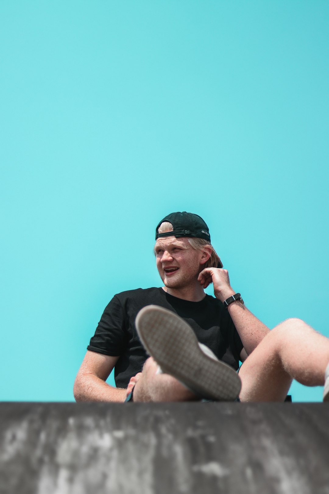 man in black crew neck t-shirt wearing black sunglasses and black cap