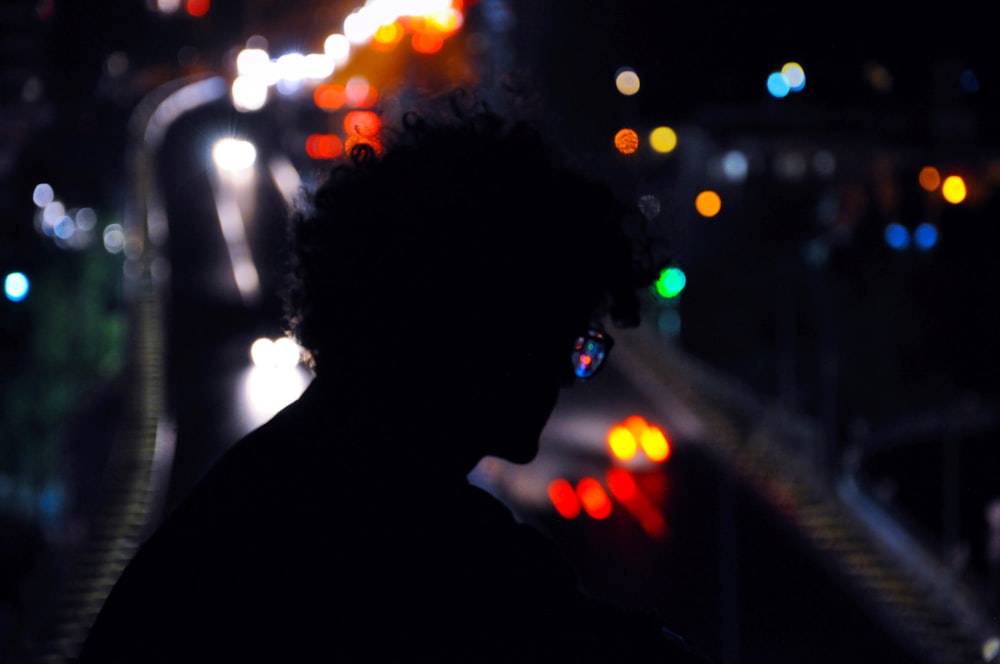silhouette of person with bokeh lights