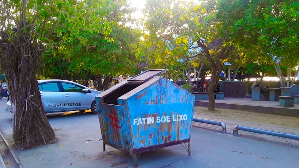 A clean, orange dumpster parked outside a residential home in Orlando on a sunny day.