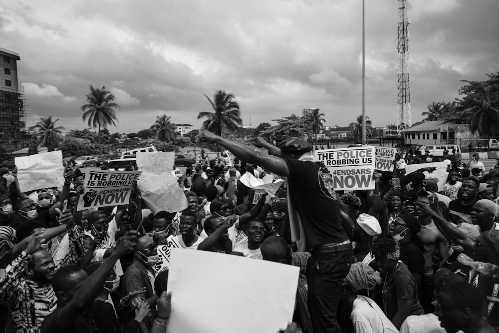 grayscale photo of people gathering on street