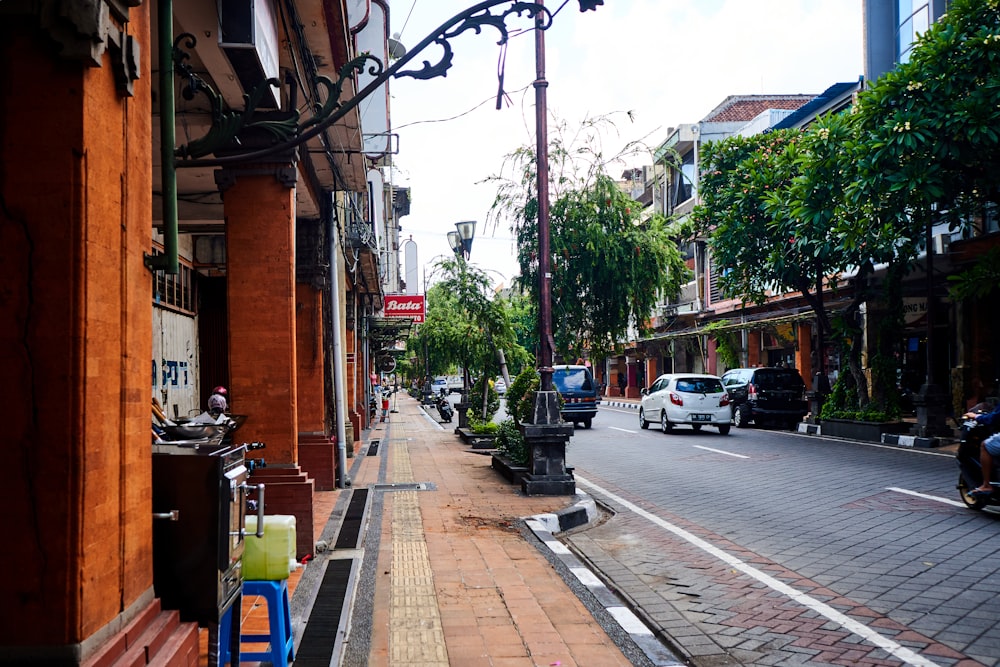 cars parked on sidewalk near buildings during daytime