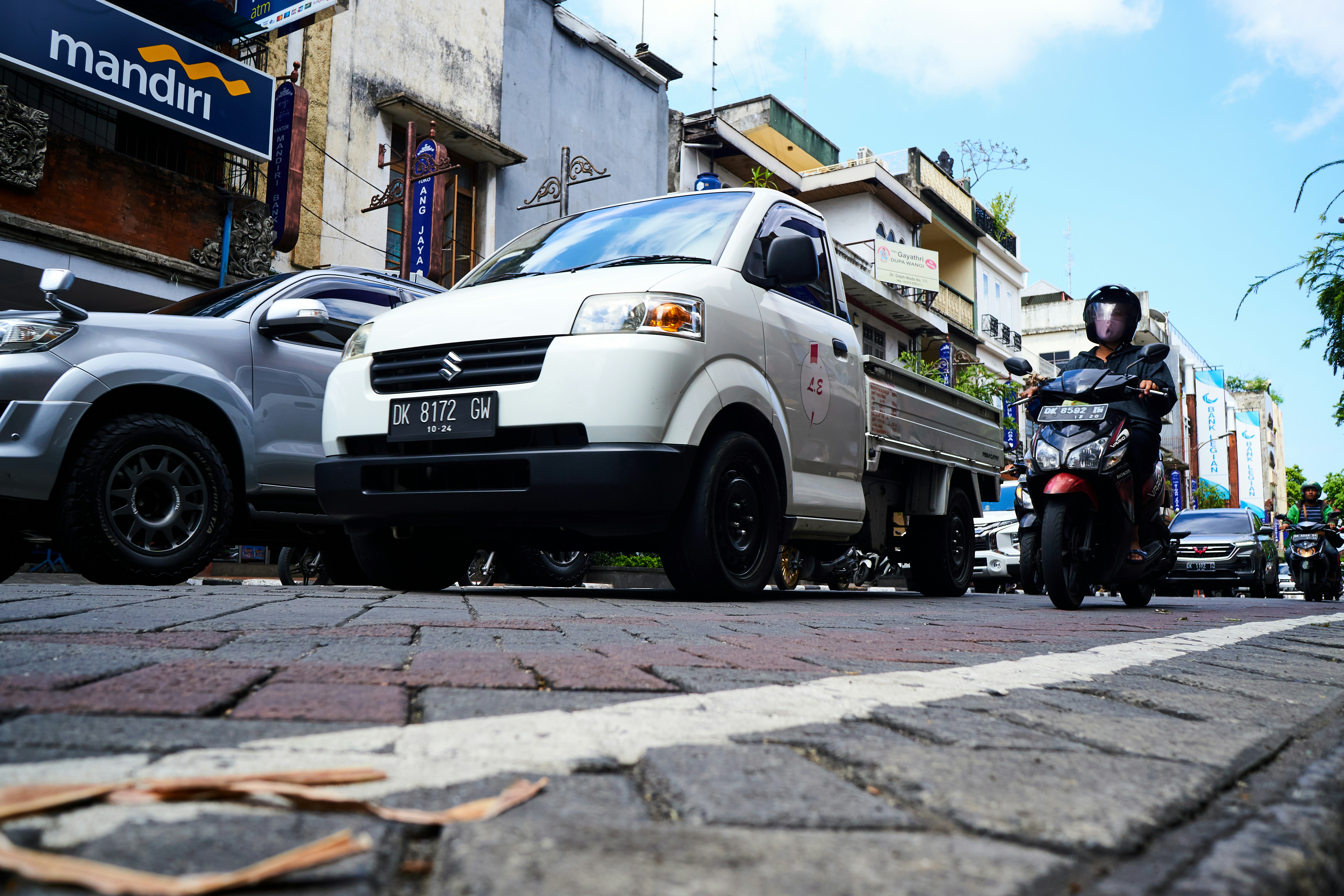 Mobil Honda putih diparkir di trotoar pada siang hari