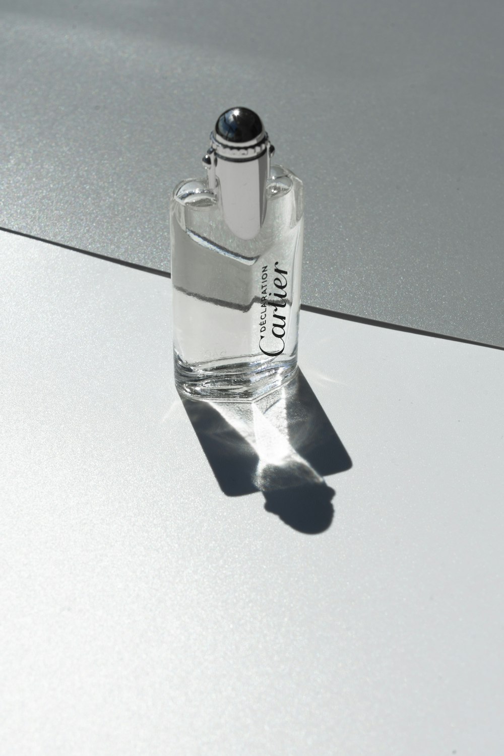 clear glass perfume bottle on black table
