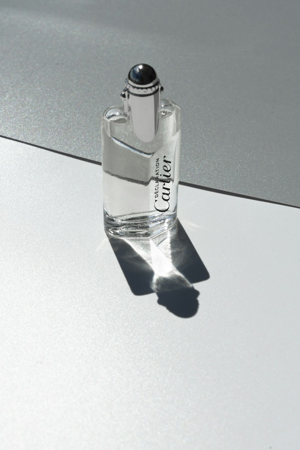 Flacon de parfum en verre transparent sur table noire