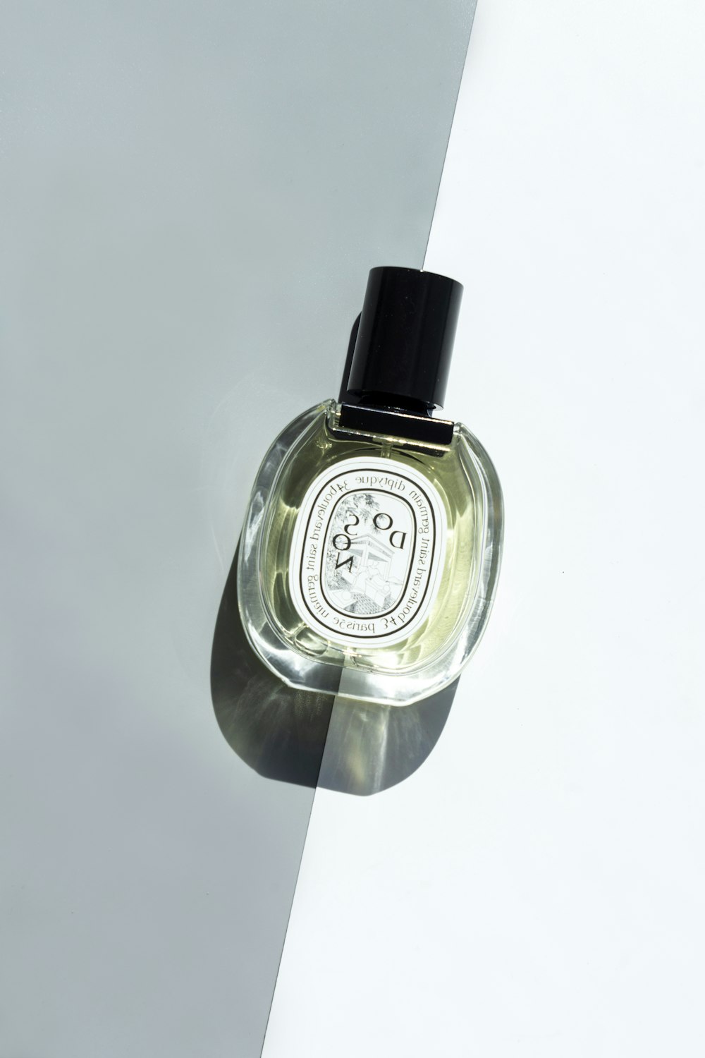 clear glass perfume bottle on white table