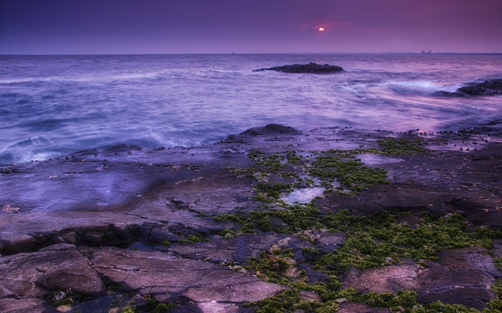 ocean waves crashing on rocks during sunset