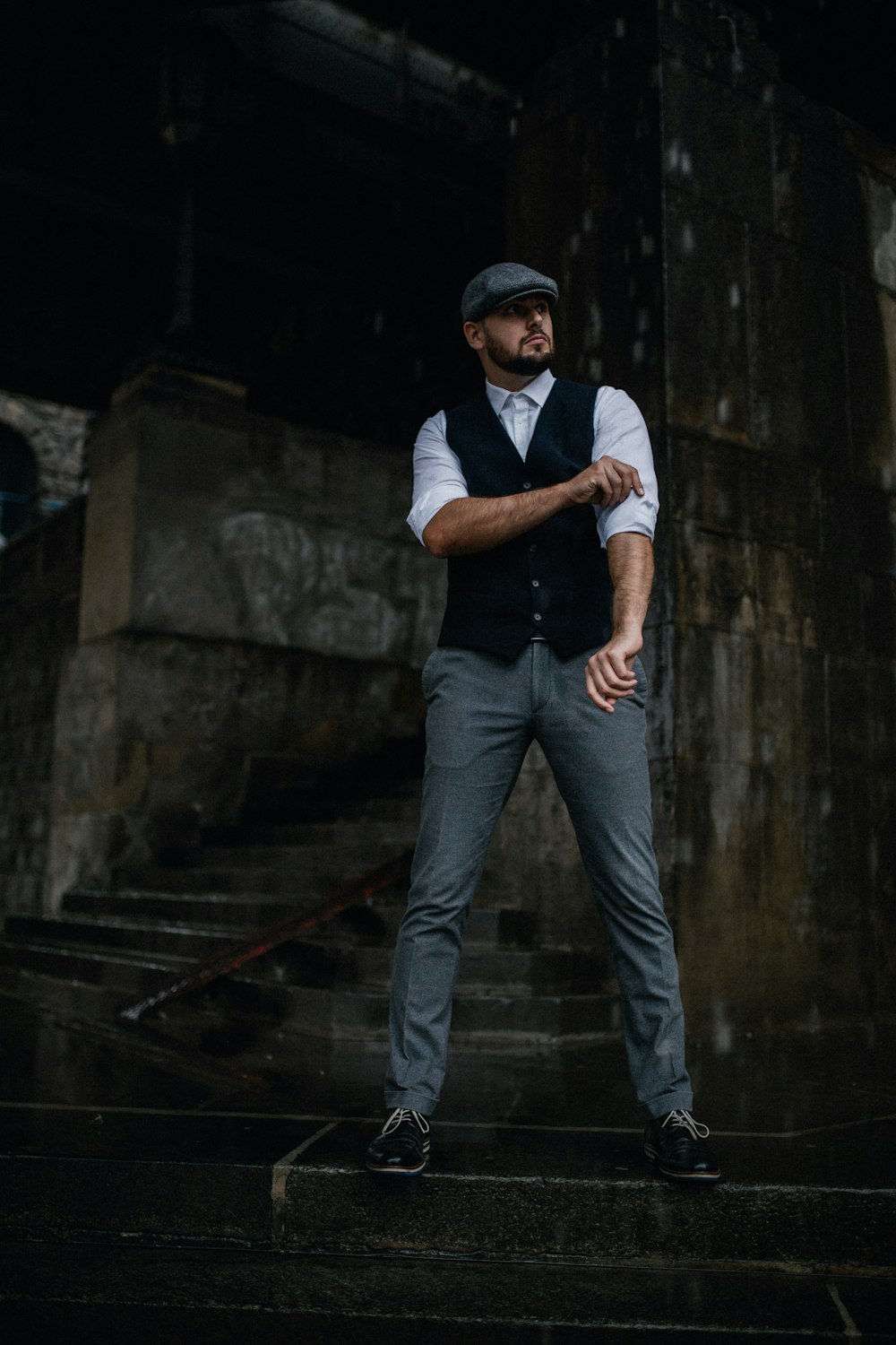 man in white polo shirt and blue denim jeans standing on stairs