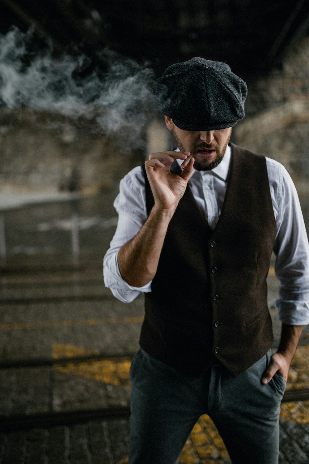 man in black vest and white dress shirt smoking cigarette