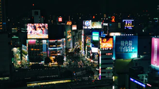 A vibrant cityscape at dusk with illuminated billboards and people walking, representing global news coverage.