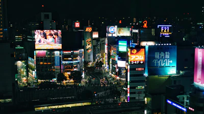 Wide shot of a bustling cityscape with multiple LED advertising screens visible on buildings.