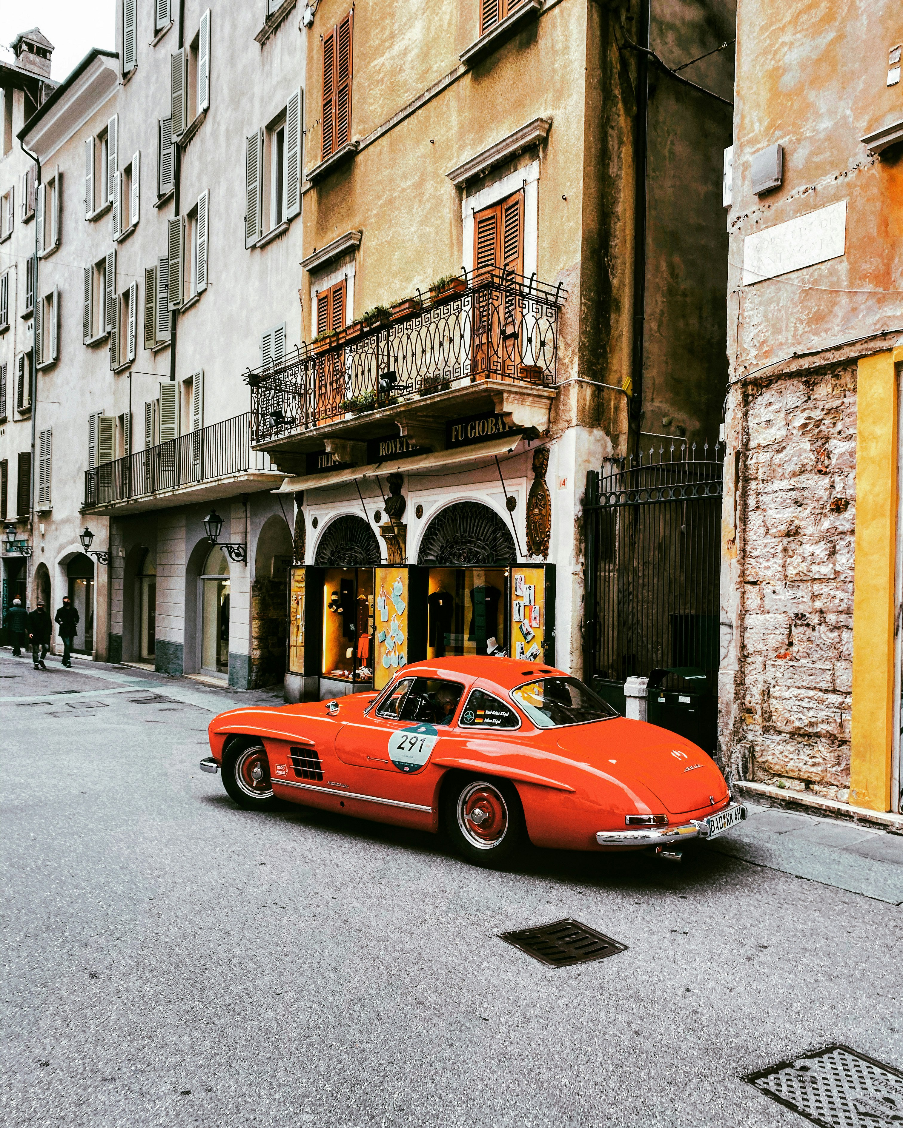 red ferrari 458 italia parked beside brown concrete building during daytime