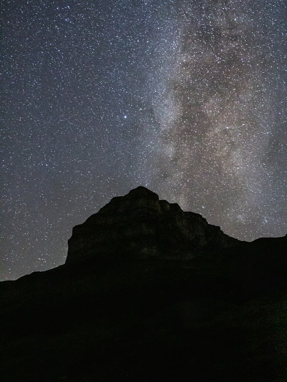 silhouette of mountain under starry night