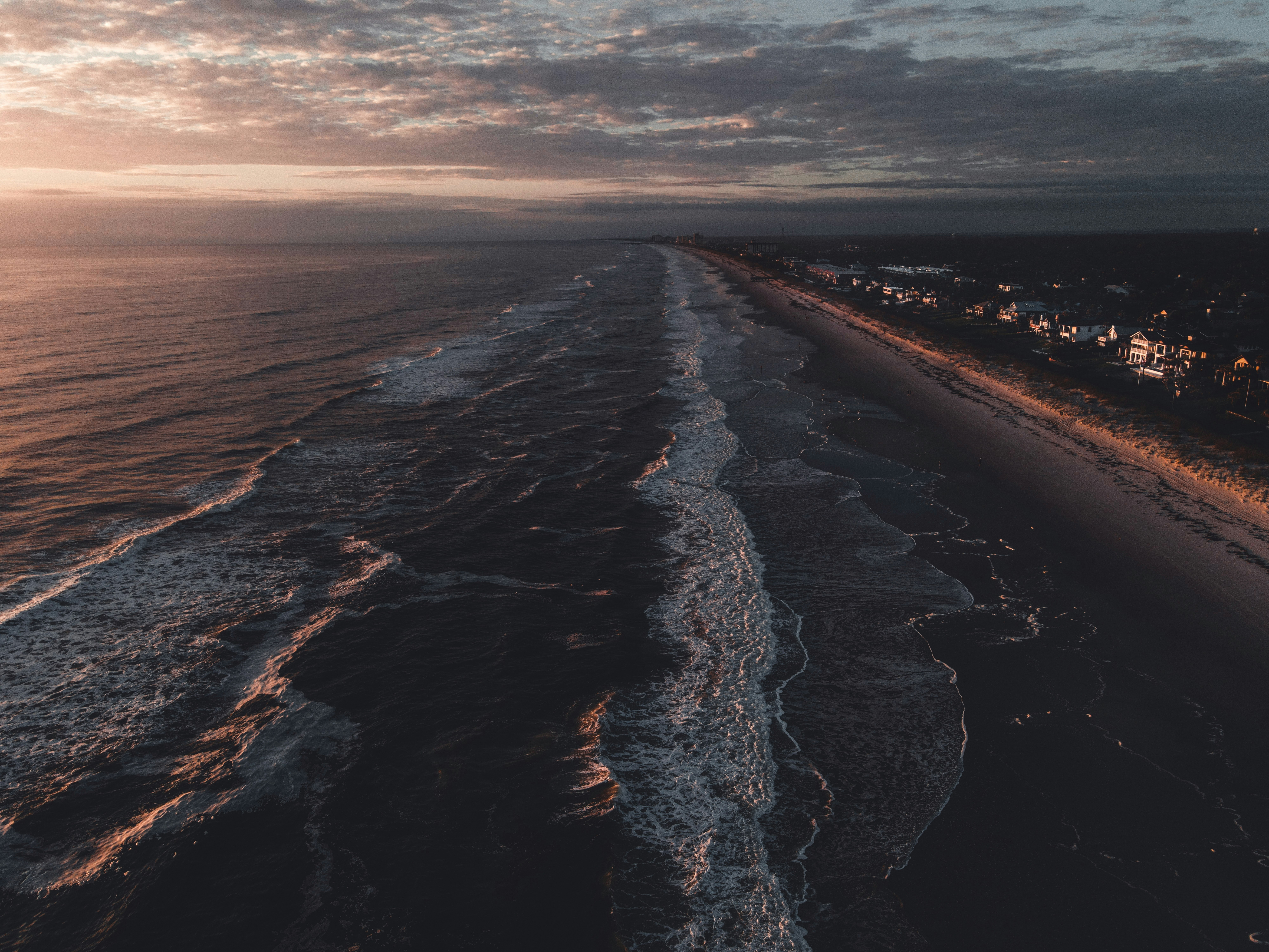sea waves crashing on shore during sunset