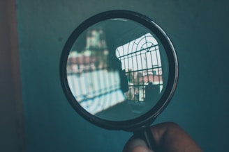 Magnifying glass over documents representing criminal record searches.