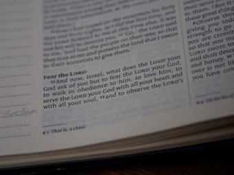 A close-up view of a page from a Bible showing a passage with some text highlighted or emphasized. The text discusses themes of devotion and obedience. The page appears slightly worn with a handwritten note in the margin.