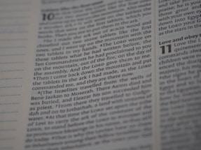 An open Bible displaying text from Deuteronomy chapter 10 to 11. The focus is on the text narrating the events related to the tablets with the Ten Commandments. The page number and chapter numbers are also visible.