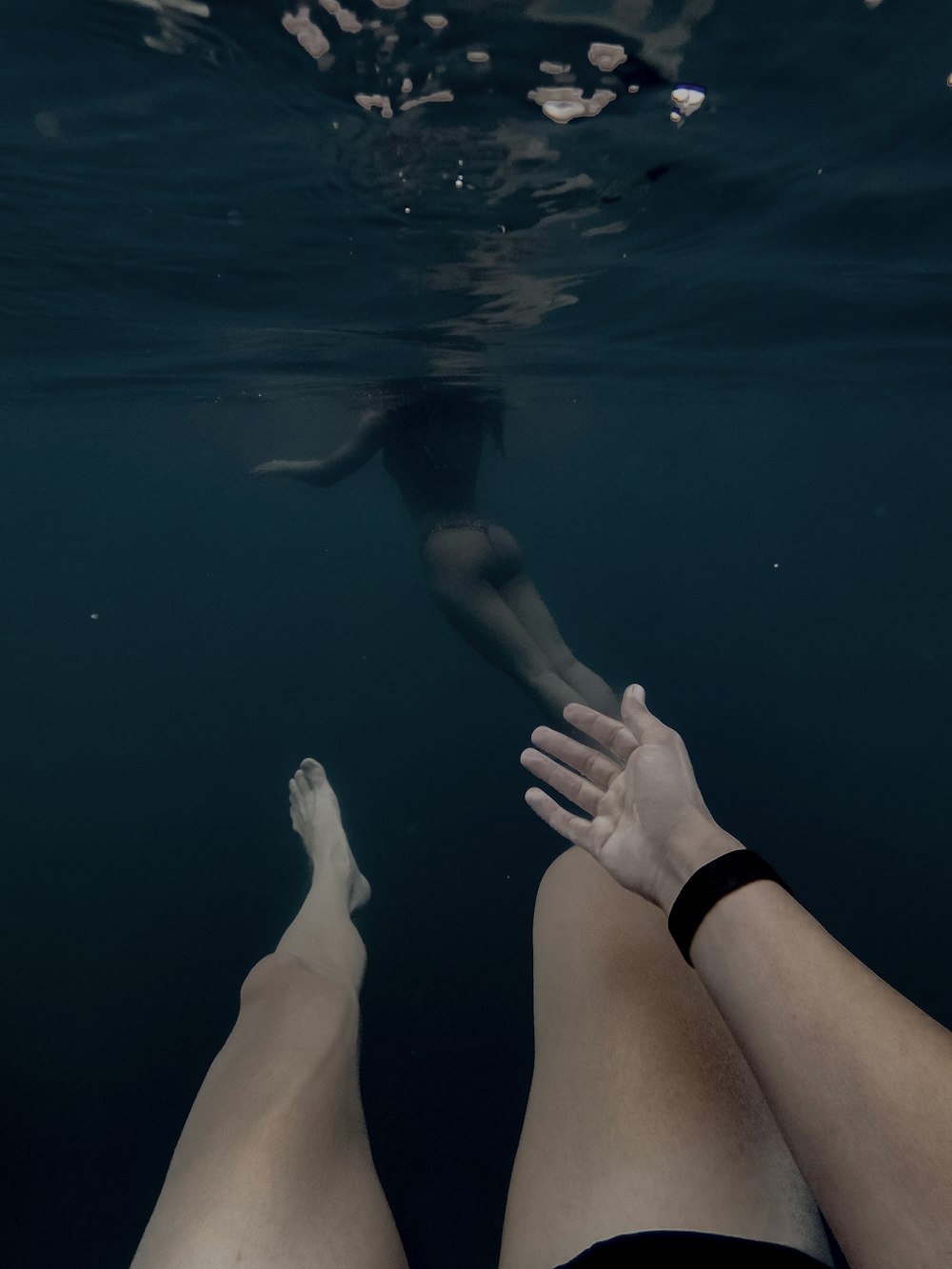 person in black shorts sitting on water