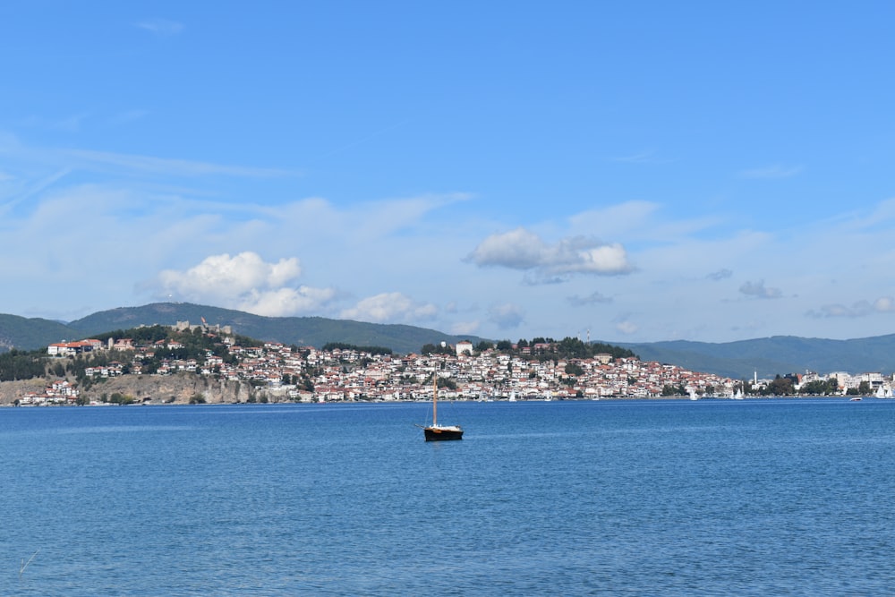 black boat on sea under blue sky during daytime