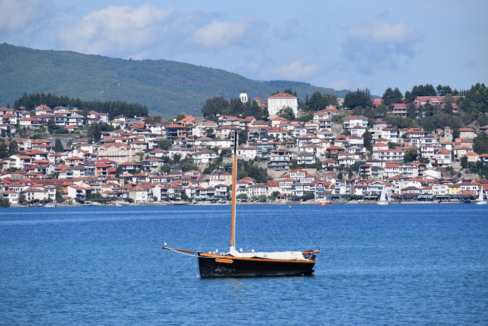 brown boat on body of water near city buildings during daytime