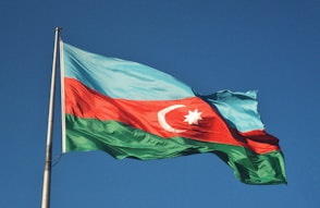 red and white flag under blue sky during daytime