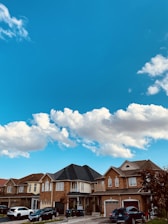 A proud Rhode Island neighborhood with homes, cars, and small businesses under clear skies.