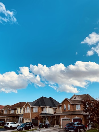 A proud Rhode Island neighborhood with homes, cars, and small businesses under clear skies.