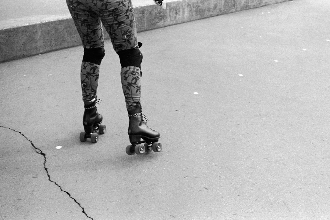 person in black and white camouflage pants and black boots standing on gray concrete floor