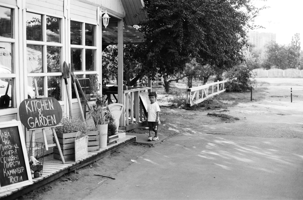 grayscale photo of man and woman walking on sidewalk