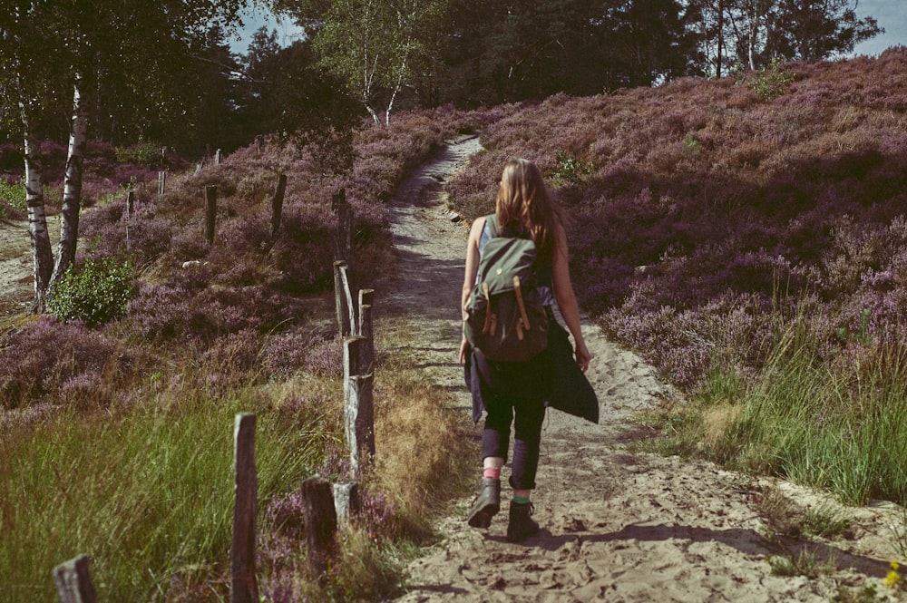 woman in brown jacket standing on rocky ground during daytime