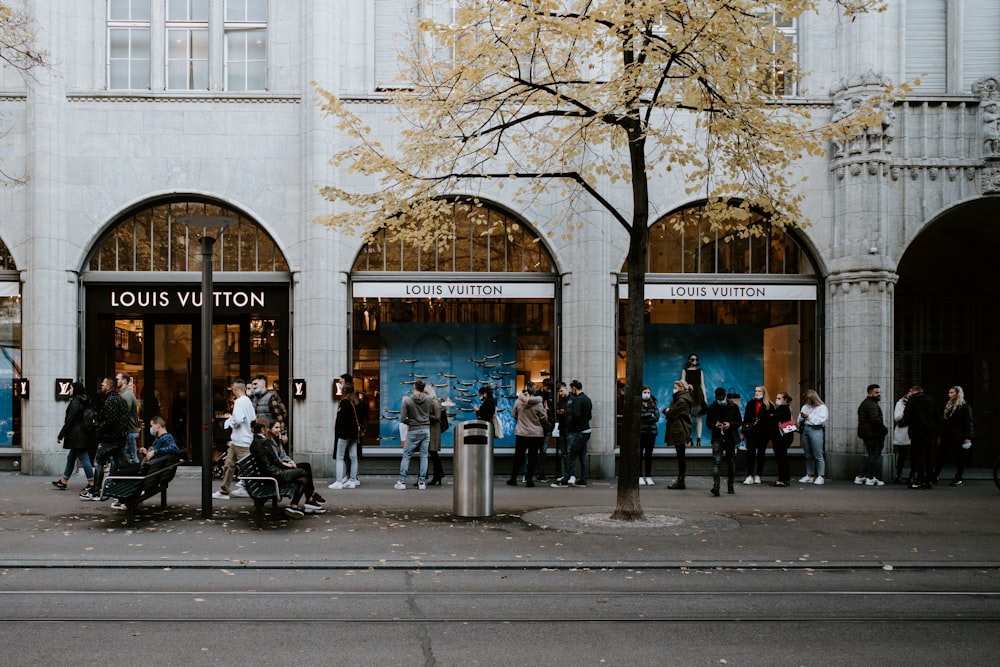 people walking on sidewalk near building during daytime