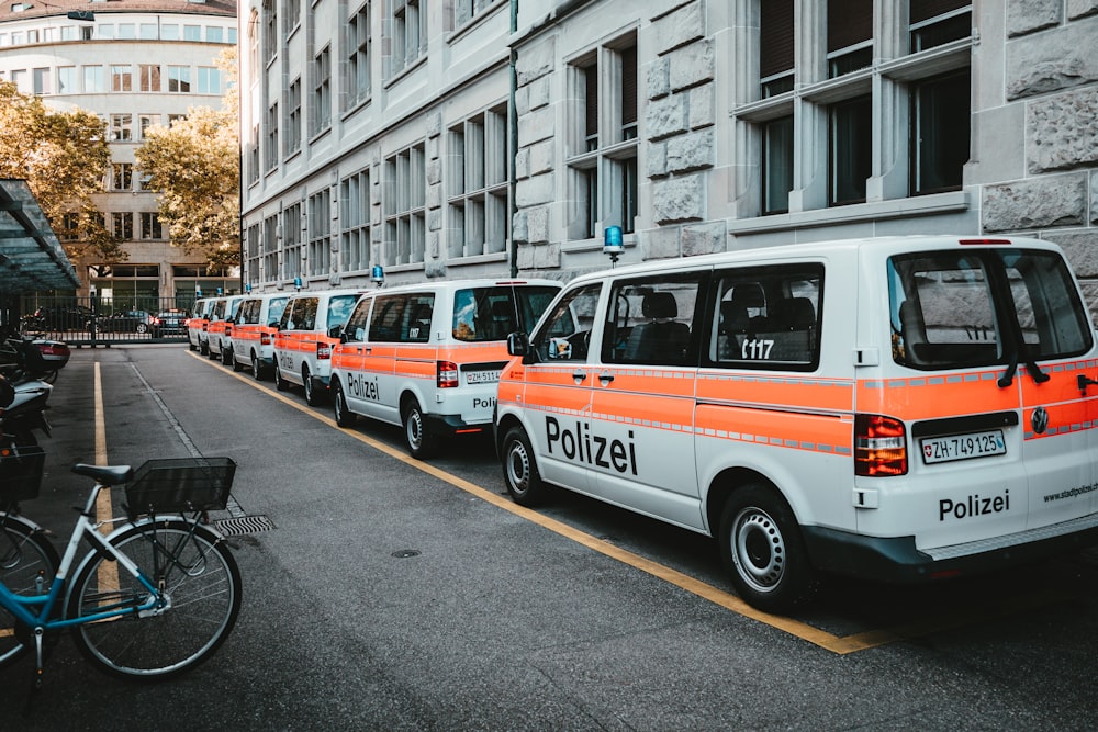 weiß-rotes Polizeiauto tagsüber unterwegs