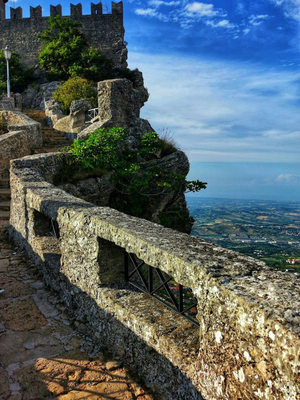 Muro de concreto gris cerca del cuerpo de agua durante el día