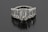 A luxurious ring featuring five large, rectangular emerald-cut diamonds set in a row. The diamonds are mounted in a shiny metal band, likely platinum, and reflect a brilliant shine against a dark background.