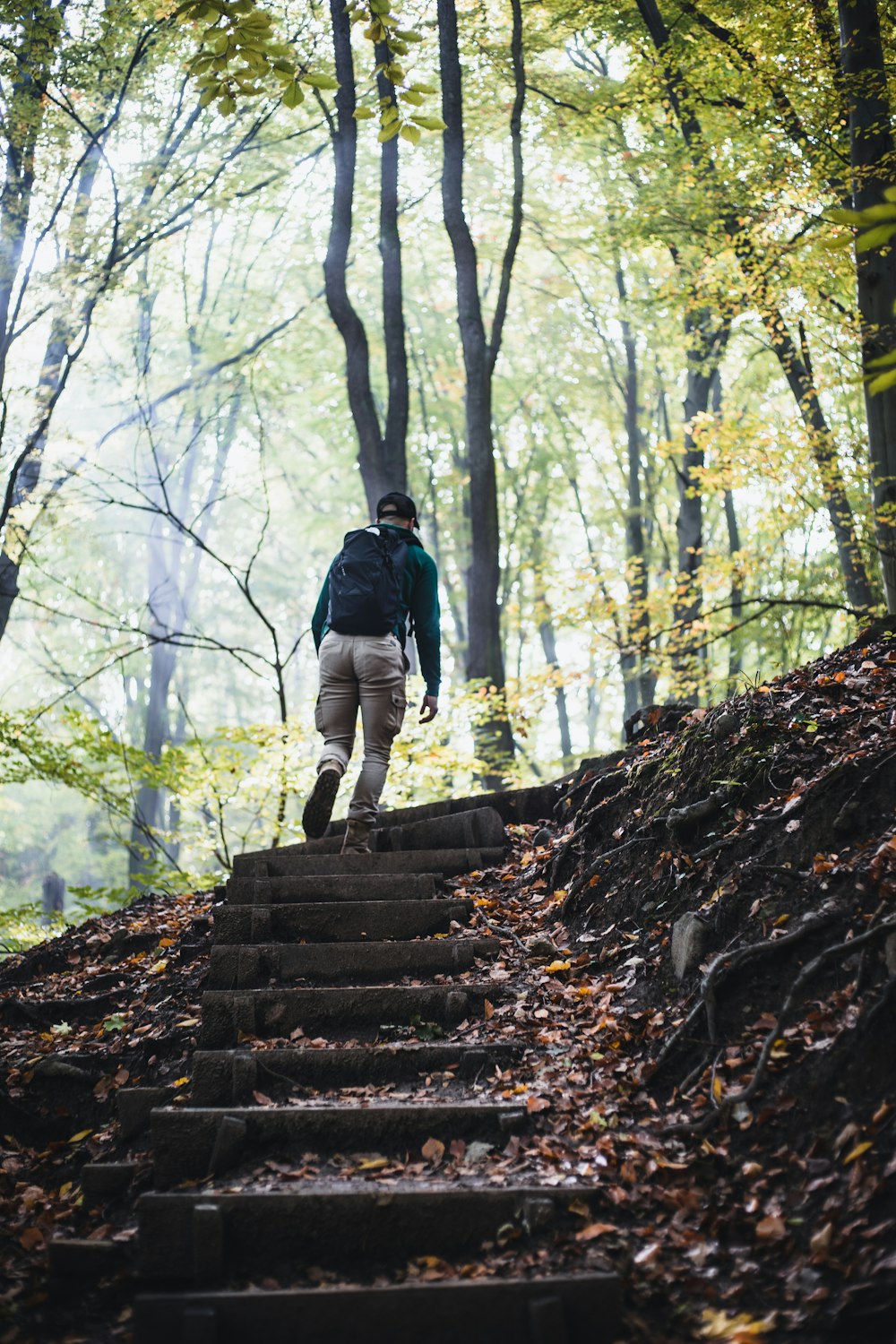 man in black jacket walking on brown concrete stairs