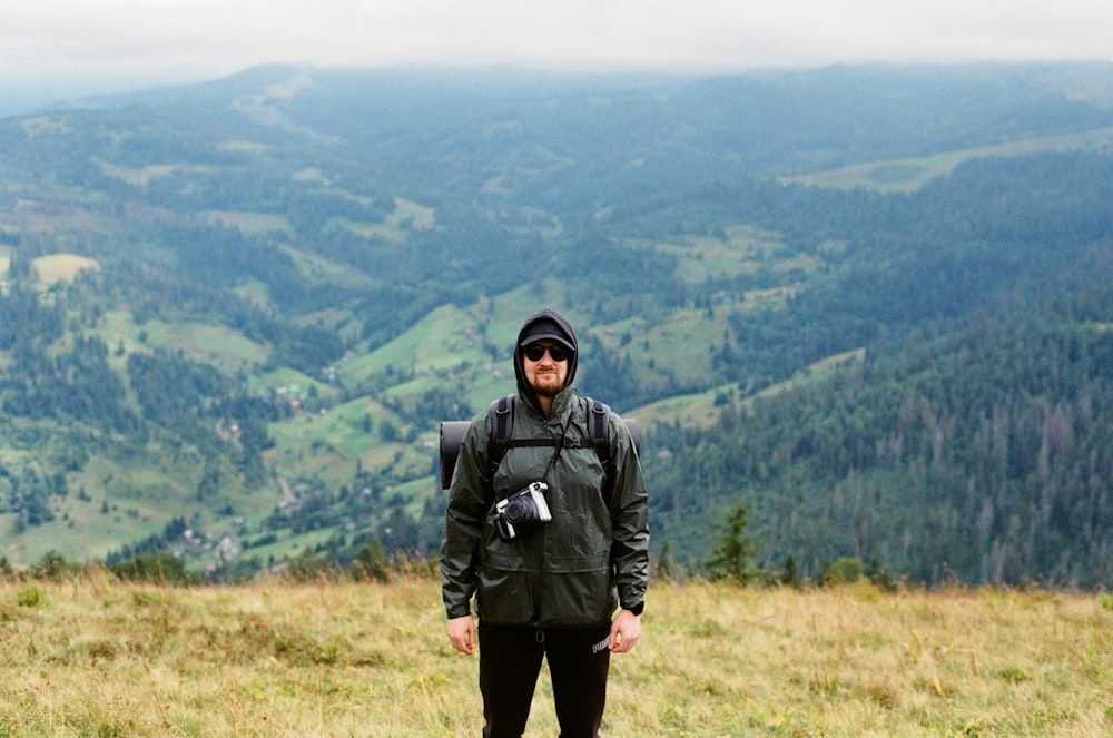 man in black jacket standing on green grass field during daytime