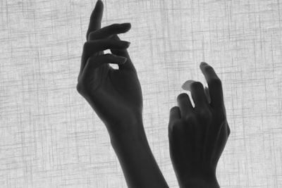 grayscale photo of persons hand delicate teams background