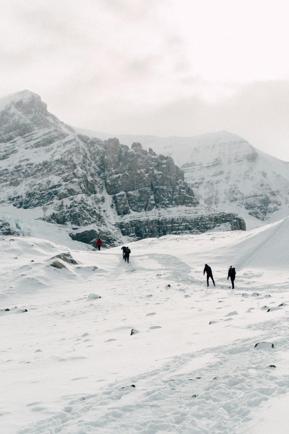 people walking on snow covered mountain during daytime