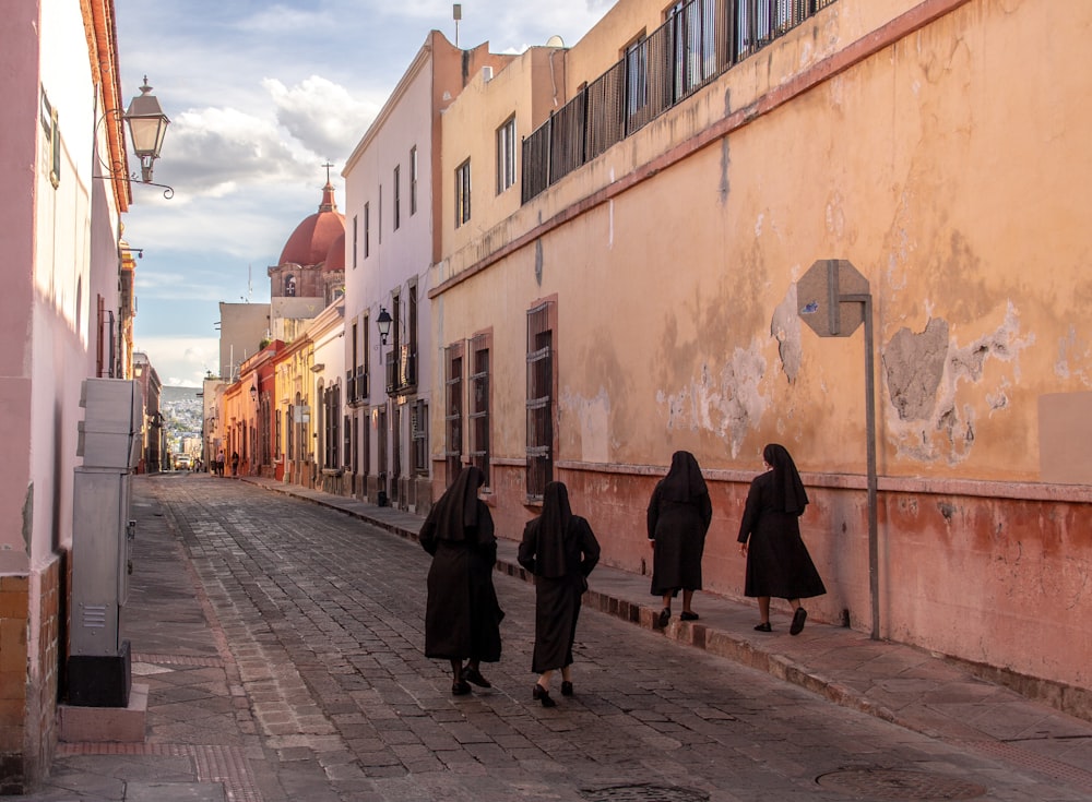 Personas que caminan por la acera cerca de los edificios durante el día