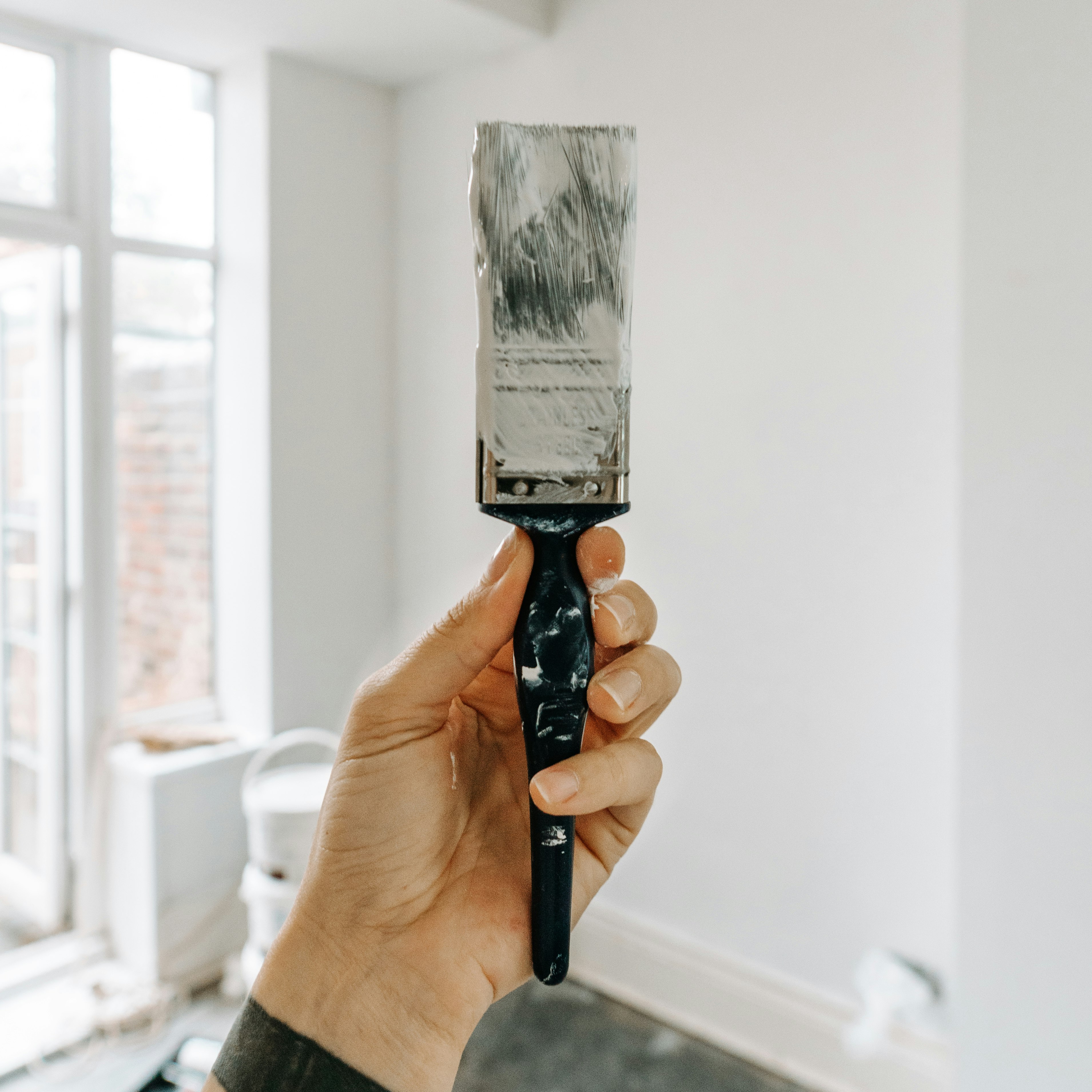 person holding white paint brush